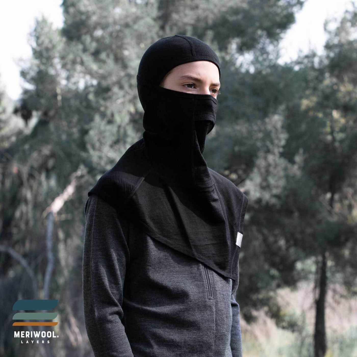 teenager standing outside young adult wearing a black merino wool 200 youth balaclava face mask